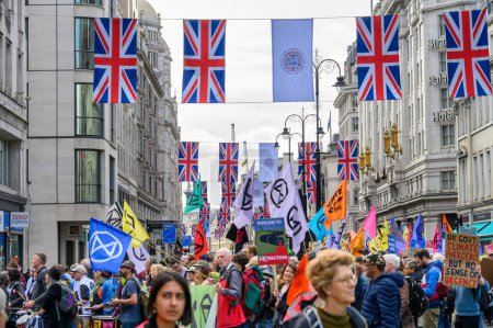 Téléchargez les photos : LONDRES - 24 avril 2023 : Le Strand de Londres devient une mer de drapeaux de protestation XR colorés sous les Union Jacks suspendus, un puissant étalage d'activisme climatique. - en image libre de droit