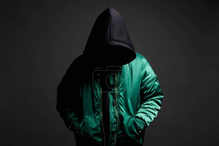 Photo for Stylish Man in Black Hood and green bomber jacket. Trendy wear Boy in a hooded sweatshirt - Royalty Free Image
