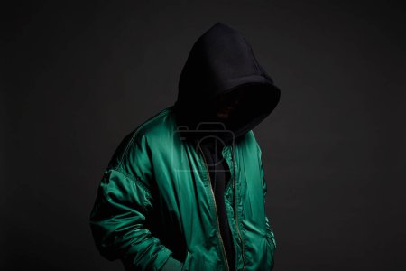 Photo for Stylish Man. Person in Black Hood and bomber jacket. Trendy wear Boy in a hooded sweatshirt - Royalty Free Image