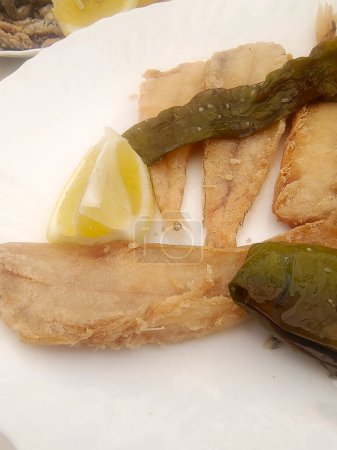 Fried fish with lemon served on a plate
