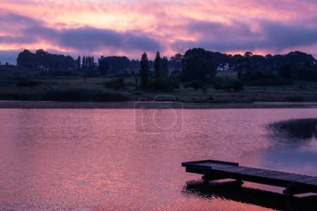 Photo for Striking colors of dawn reflected off the water in a dam - Royalty Free Image