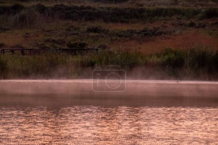 Photo for Evaporation of water from the surface of a dam at dawn - Royalty Free Image