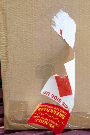 Téléchargez les photos : Boîte en carton avec marchandises avec étiquette fragile arrachée - en image libre de droit