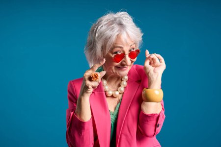 Playful Senior Lady in Heart-Shaped Sunglasses Winking