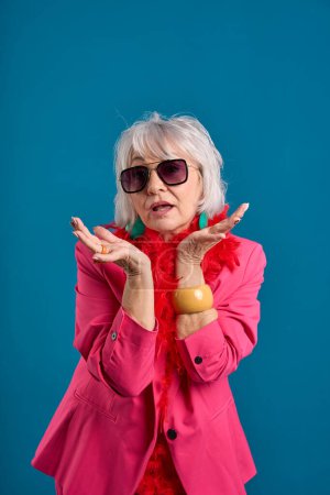 Elegante Seniorin mit Sonnenbrille macht Überraschungsgeste