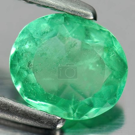 Foto de Esmeralda verde gema natural sobre fondo gris - Imagen libre de derechos