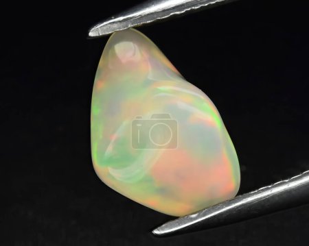 Téléchargez les photos : Pierre naturelle précieuse noble opale sur fond noir - en image libre de droit