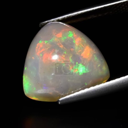 Téléchargez les photos : Opale en pierre précieuse naturelle sur fond noir - en image libre de droit