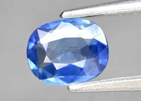 Espinela azul gema natural sobre un fondo gris