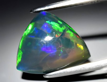 Téléchargez les photos : Pierre naturelle précieuse noble opale sur fond noir - en image libre de droit