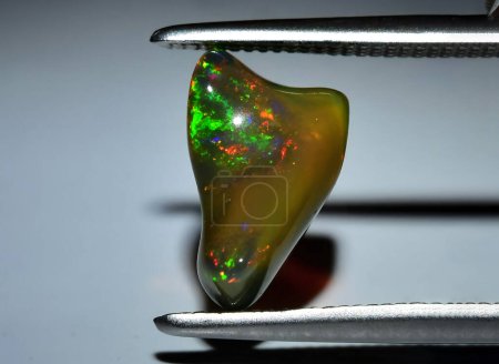 Téléchargez les photos : Arc-en-ciel naturel multicolore opale gemme rugueuse sur fond - en image libre de droit