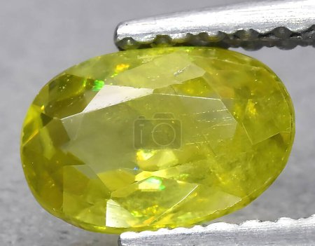 Photo for Natural yellow green sphene gem on background - Royalty Free Image