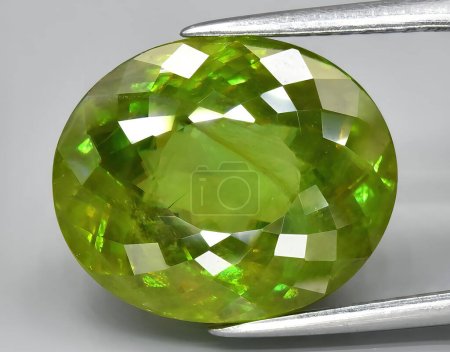 Photo for Natural yellow green sphene gem on background - Royalty Free Image