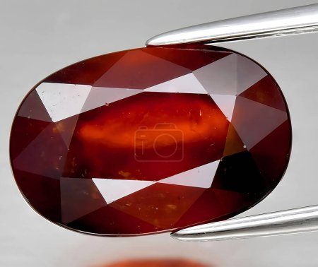 natural red hessonite garnet gem on background
