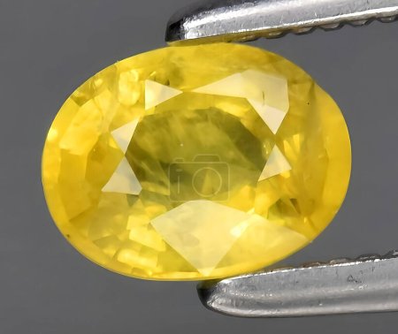 natural yellow sapphire rough gem on background