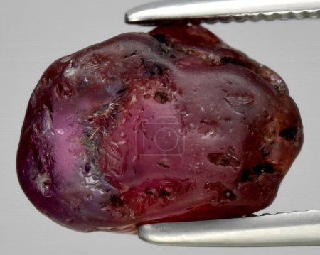 natural red ruby rough gem on background