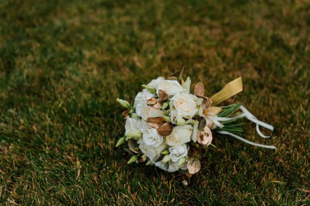 Téléchargez les photos : Une paire d'alliances en or sur un bouquet de fleurs blanches. Bagues en or sur un bouquet de roses - en image libre de droit