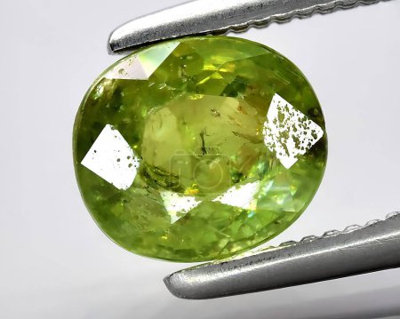 natural green demantoid garnet gem on background