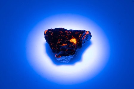 pierre gemme yooperlite naturelle dans la lumière UV sur fond blanc