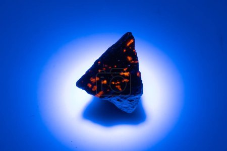 Naturyooperlith Edelstein im UV-Licht auf weißem Hintergrund