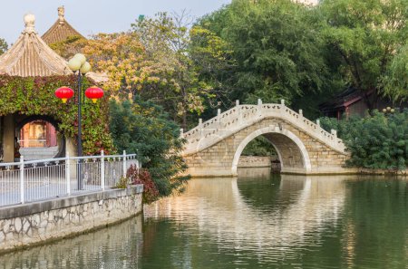 Traditional chinese arch bridge in Renmin park in Tianjin, China