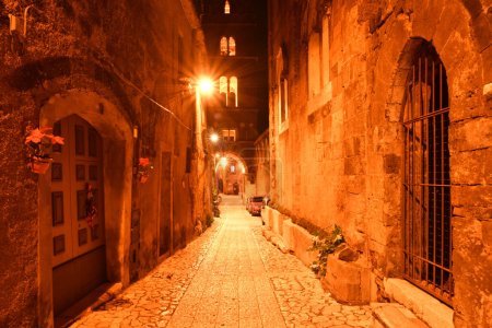 Foto de Una calle estrecha entre las antiguas casas de piedra de un barrio medieval de la ciudad de Caserta, Italia. - Imagen libre de derechos