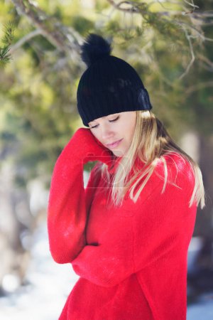 Photo for Sweet blonde woman in a snowy forest in the mountains, in Sierra Nevada, Granada, Spain. Female wearing winter clothes. - Royalty Free Image