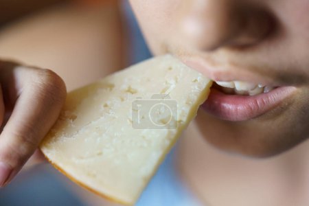 Photo for From above closeup of crop anonymous teenage girl eating fresh cheese at home - Royalty Free Image