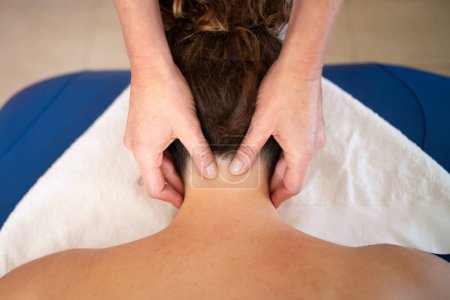Foto de Vista superior del cultivo anónimo terapeuta femenina frotando el cuello suavemente durante el masaje relajante en el salón de spa - Imagen libre de derechos