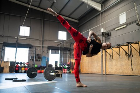 Foto de Foto horizontal con espacio de copia de una mujer deportiva pateando en el aire en un gimnasio - Imagen libre de derechos