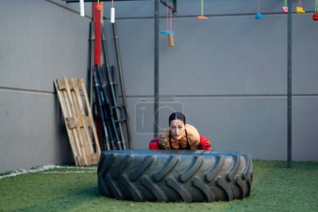 Foto de Fotografía horizontal con espacio de copia de una mujer fuerte haciendo ejercicio con una rueda en un gimnasio - Imagen libre de derechos