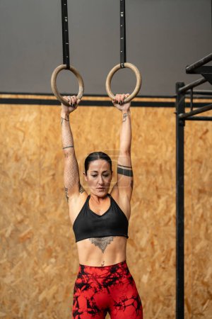 Téléchargez les photos : Photo verticale d'un anneau olympique d'entraînement féminin dans un centre d'entraînement transversal - en image libre de droit
