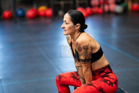 Photo for Mature sportive woman resting sitting on a box in a gym - Royalty Free Image