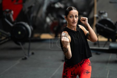 Mujer artista marcial entrenando en un gimnasio shadowboxing trowing un uppercut