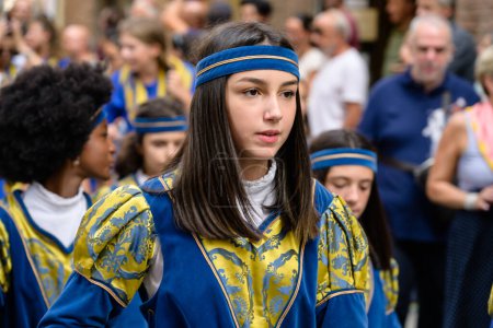 Photo for Siena, Italy - August 14 2022: Processione del Cero Votivo Procession Flower Girl in Traditional Costume of the Tartuca Contrada at the Palio di Siena. - Royalty Free Image