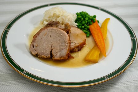 Foto de Carne asada con riñón o Kalbsbraten al estilo de Austria con arroz, guisantes y salsa - Imagen libre de derechos