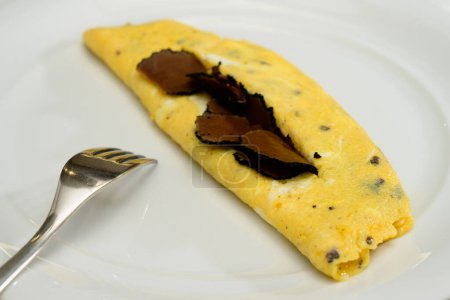 Téléchargez les photos : Omelette à la truffe française Oeufs ou omelette auc Truffes aux truffes noires d'été sur une assiette blanche - en image libre de droit