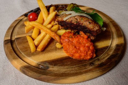 Cevapcici Balkan Style Meatballs with Ajvar Sauce, Onions, Parsley, French Fries and Grilled Pepper