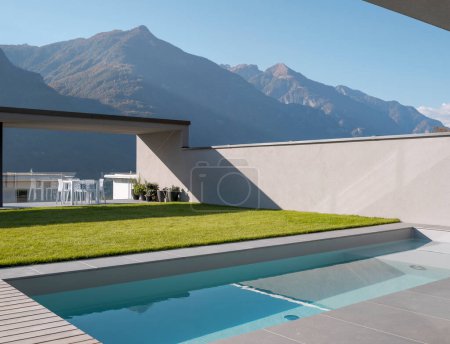 Schwimmbad mit Blick auf die Schweizer Alpen. Es gibt einen Garten und eine Terrasse. Niemand drinnen