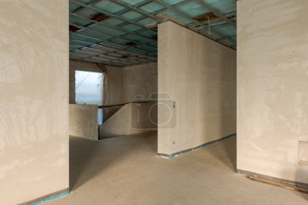 Photo for Entrance hall with empty staircase newly renovated, walls still raw, no windows and no floor. Construction site in progress. Nobody inside - Royalty Free Image