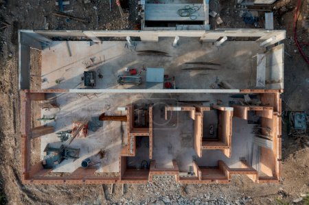 Foto de Aerial drone view of an outbuilding under construction, roofless with walls made of bricks. Around it is the building site. Nobody inside - Imagen libre de derechos