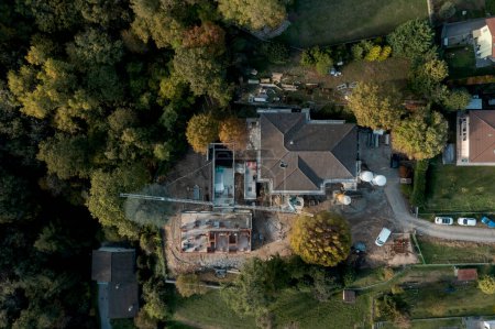 Foto de Aerial drone view of a construction site of an old villa with garden under renovation and an outbuilding under construction. All around is nature. Nobody inside - Imagen libre de derechos