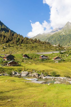 Foto de Pequeño pueblo de montaña enclavado en las verdes montañas suizas. Día soleado de verano. Nadie dentro. - Imagen libre de derechos