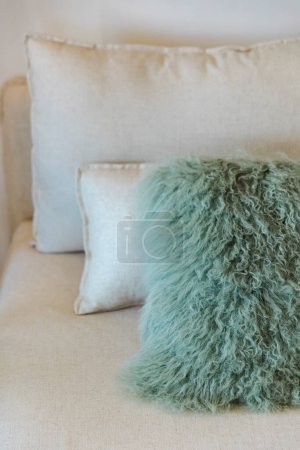 Téléchargez les photos : Détail de trois oreillers, un en fourrure turquoise et deux en beige, placés sur un lit. Personne à l'intérieur - en image libre de droit