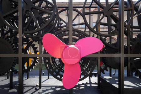 Foto de Estructura de engranajes de metal negro con una gran hélice rosa en el centro. Nadie despierta. - Imagen libre de derechos