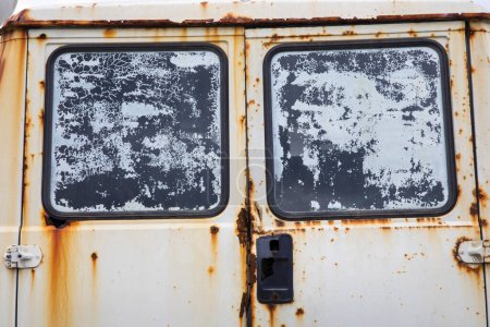 Photo for Detail of the rear window of an abandoned old white van with a lot of rust. The windows are dirty and the handle to open the trunk is broken. - Royalty Free Image