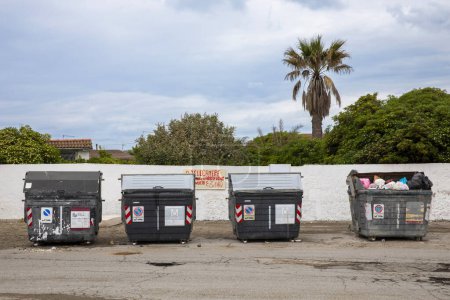 Foto de Grandes botes de basura abiertos con basura esparcida por todas partes, es solo grosería. Zona degradada de la ciudad - Imagen libre de derechos