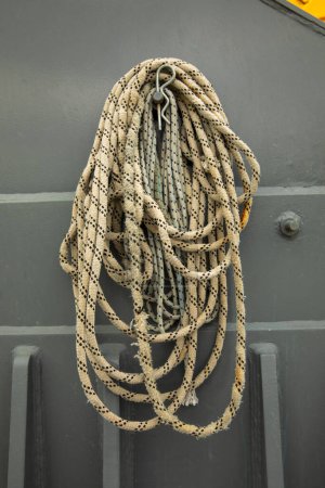 Foto de Detalle de un gancho con una cuerda apoyada sobre él dentro de un puerto. Copiar espacio - Imagen libre de derechos