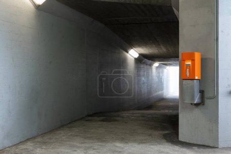 Foto de Detalle de la máquina de validación de billetes naranja en el corredor peatonal bajo la estación de tren. Nadie dentro. - Imagen libre de derechos