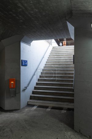Téléchargez les photos : Détail d'un escalier dans une gare avec la machine de validation des billets orange à côté. Personne à l'intérieur - en image libre de droit